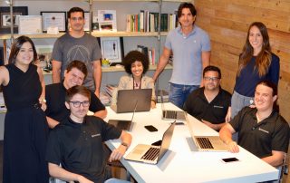 abartys health team members sitting around a table with their laptops smiling for a photo