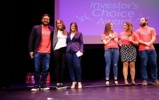 three members of the abartys health team posing on stage for the investor's choice awards