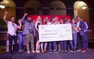 abartys health team holding a giant one hundred thousand dollar check