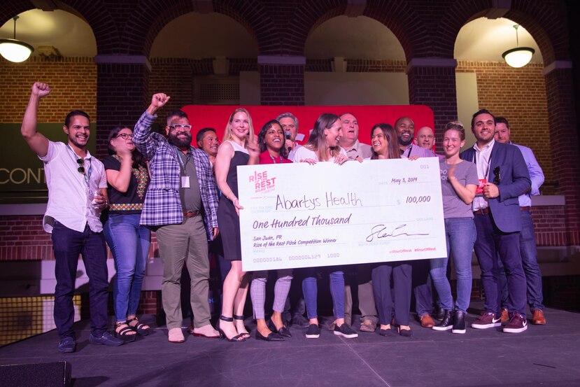 abartys health team holding a giant one hundred thousand dollar check